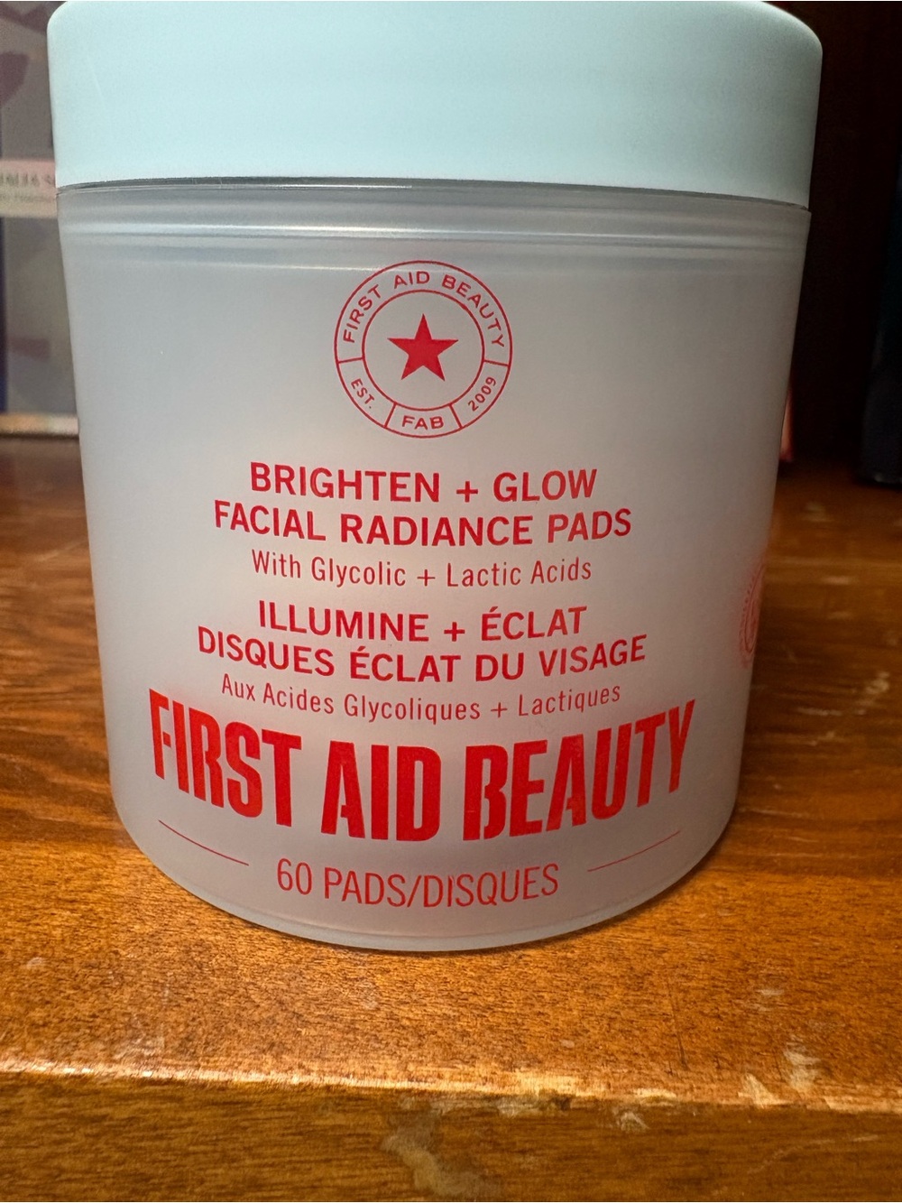 First Aid Beauty white jar with bold red logo Facial Radiance Pads
